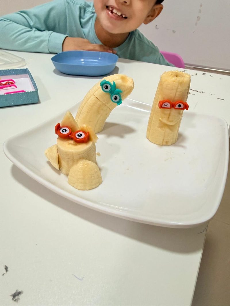 Trozos de banana convertidos en personajes con ojos de juguete, en una sesión de trabajo con la alimentación