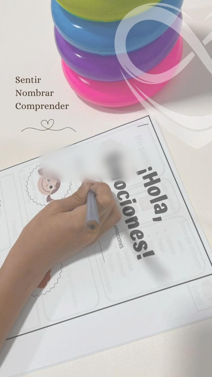 La mano de un niño completa una lámina de trabajo titulada Hola, Emociones