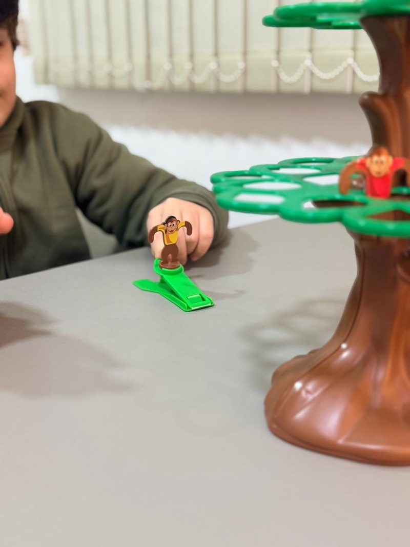Un niño apunta con la catapulta de un juego de equilibrio con forma de árbol durante la sesión