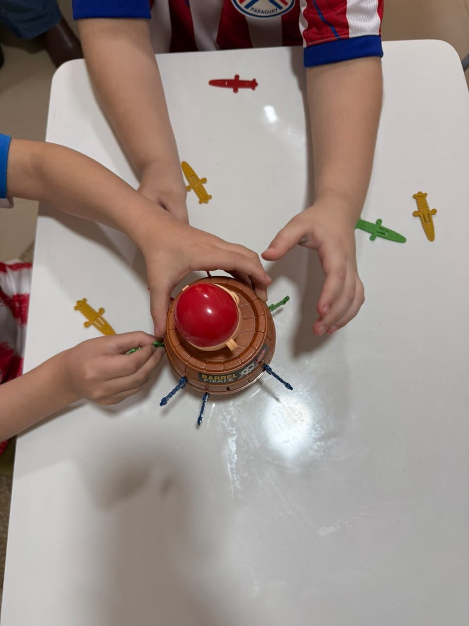 Las manos de dos niños jugando juntos un juego de mesa en una sala de terapia