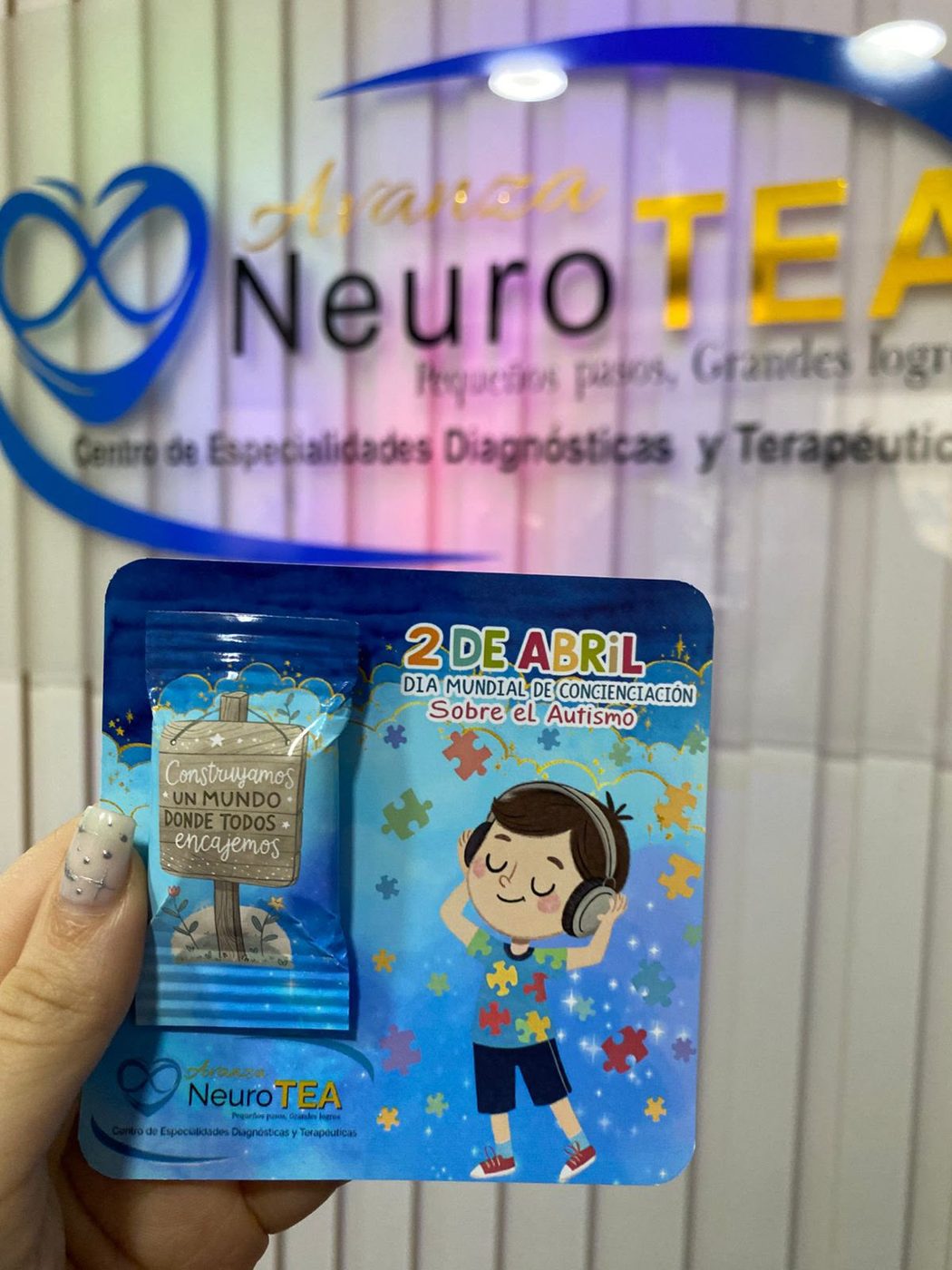Un souvenir del Día Mundial de Concienciación sobre el Autismo frente al cartel de la clínica